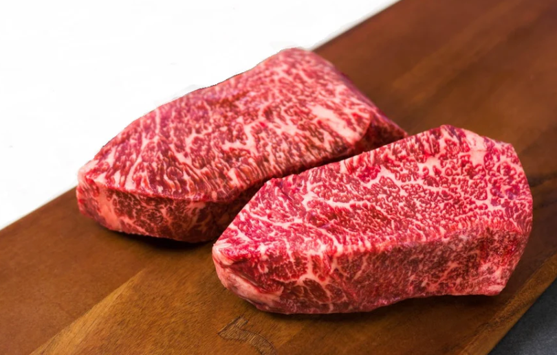 ¿Qué significa Wagyu A5? El Wagyu A5 es la calificación más alta que puede recibir la carne en Japón, el A5 indica la alta calidad y confirma el cuidado bajo estrictos estándares de calidad, entre los que destacan: El grado de marmóleo, en una escala de 8 a 12, es decir, un nivel alto de grasa intramuscular. El Wagyu japonés es conocido mundialmente por su calidad, es considerada una verdadera joya culinaria. Wagyu significa “vaca japonesa” que es un término que se les da a varias razas de ganado de alta calidad. En Japón, el cuidado del Wagyu se considera una fusión entre ciencia y arte, es un ejemplo de devoción, se rigen bajo principios que aseguren la más alta calidad. En primera instancia, realizan una selección genética, revisando de manera meticulosa las líneas de sangre para mantener la pureza de la raza. Además de que les dan una dieta estricta, basada en arroz, cebada, trigo y maíz e incluso en algunos casos, sake (la bebida alcohólica basada en arroz) o cerveza.