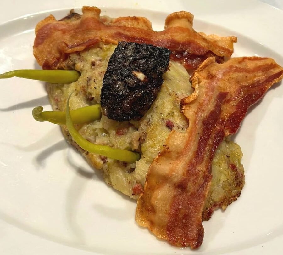 Elaborat amb productes de la terra, la senzillesa de la col i la intensitat del bacó i la patata, donant com a resultat un plat senzill però extraordinàriament saborós.
