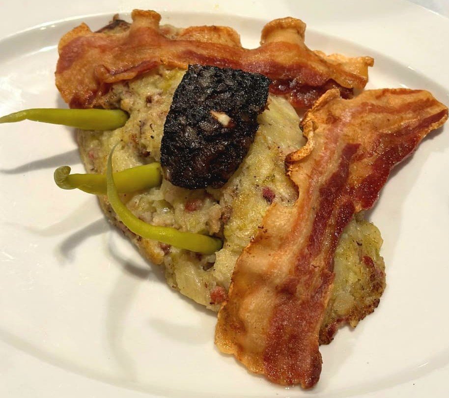 Elaborat amb productes de la terra, la senzillesa de la col i la intensitat del bacó i la patata, donant com a resultat un plat senzill però extraordinàriament saborós.